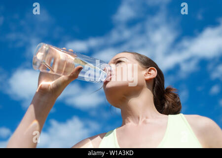 Frau trinkt aus einem wiederverwendbaren Glas Flasche Wasser Stockfoto