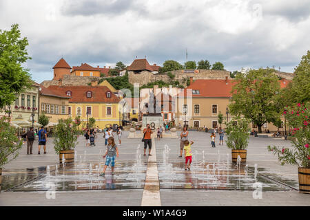 EGER. Ungarn - 18. JULI 2016: Istvan Dobo Platz mit einem Brunnen im Vordergrund und das Schloss in Eger im Hintergrund. Ungarn Stockfoto