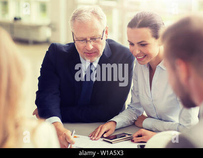 Architekten mit Smartphone und Blaupause im Büro Stockfoto