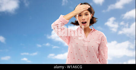 Verwirrte junge Frau im Pyjama über das Sky Stockfoto