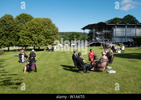 Garsington Opera UK; die Leute draußen sitzen trinken Champagner und genießen den Sommer Sonnenschein, Garsington Opera, Wormsley Immobilien England Großbritannien Stockfoto
