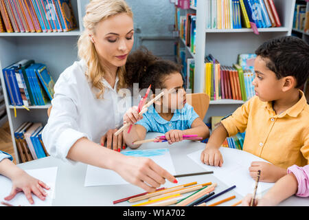 7/8-Ansicht der Zicklein, die Zeichnung in der Nähe der afrikanischen amerikanischen Kinder und Lehrer Stockfoto