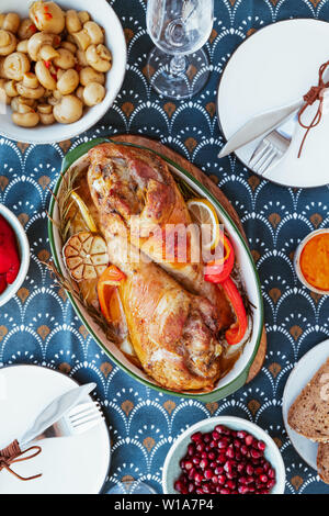 Festliche Schale für Thanksgiving, gebratener Truthahn Beine mit Gemüse auf einem Tisch mit Snacks. Ansicht von oben, flach. Stockfoto