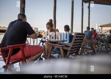 Belgrad, Serbien, 27. Juni 2019: städtische Szene mit Menschen in einem Café Terrasse an der Donau Riverside Promenade sitzen in Zemun Stockfoto