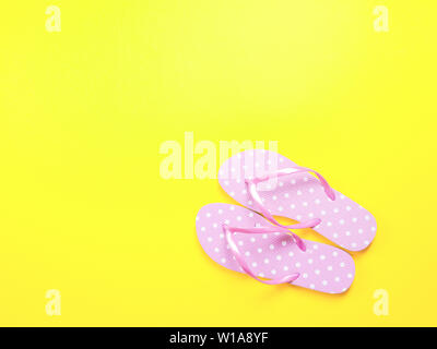 Ansicht von oben Bild von Rosa flip flops auf gelben Hintergrund. Sommer Trevélez und Ferienhäuser Konzept Stockfoto