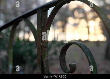 Nahaufnahme von Metall rostigen Geländer eines kleinen alten Brücke mit Spirale Elemente und einige grüne Moos auf. Stockfoto