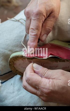 Schuster näht einen Schuh listig, mit Garn und Awl. Stockfoto