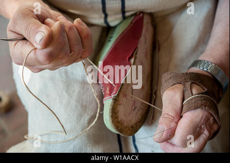 Schuster näht einen Schuh listig, mit Garn. Stockfoto