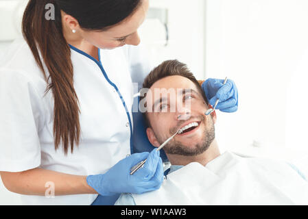 Mann, der Zähne Zahnärzte untersucht. Übersicht von Karies Vorbeugung Stockfoto