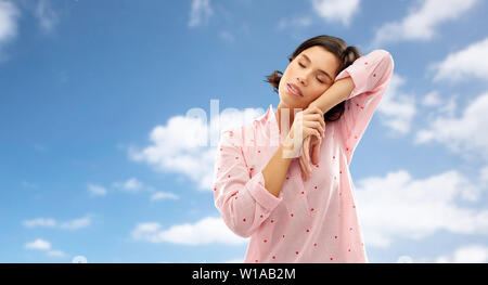 Schläfrige Frau in Pyjama über das Sky napping Stockfoto