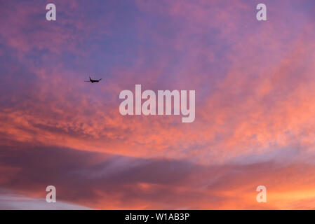 Passagiermaschine über eine bunte Himmel fliegen Stockfoto