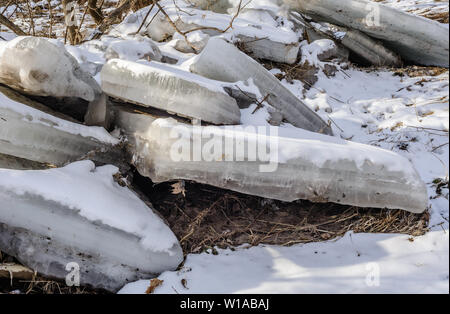 Dicken Platten von gefrorenem Eis gebrochen und an der Küste im Winter angehäuft. Stockfoto