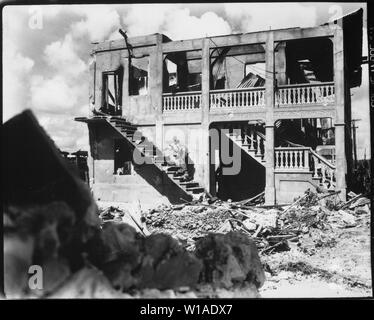 Ein Marine aus dem dritten Geschäftsbereich Marine geht nach einem Sniper in einem mit einer Schale versehenen Gebäude. Guam, August 1944; Allgemeine Hinweise: Verwenden Sie Krieg und Konflikt Nummer 1190 bei der Bestellung eine Reproduktion oder Anforderung von Informationen zu diesem Bild. Stockfoto