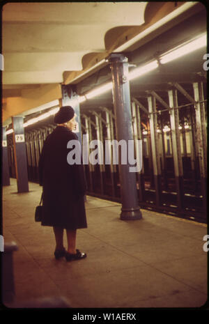 Eine Frau wartet auf einen Zug am 79 TH STREET STATION Stockfoto