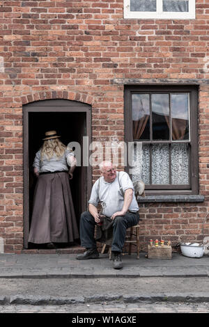 Zwei Personen im Edwardianischen Kleidung außerhalb ein Reihenhaus gekleidet, Black Country Living Museum, Dudley GROSSBRITANNIEN Stockfoto