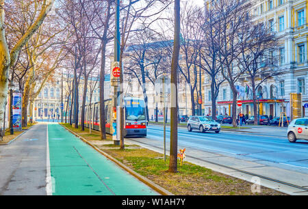 Wien, Österreich - 18. FEBRUAR 2019: Die moderne Straßenbahn ridel zusammen zahlreiche schöne Gebäude an der berühmten Ringstraße, am 18. Februar in Wien. Stockfoto