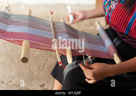 Nahaufnahme der Hand einer Frau, die das Weben auf einem alten hölzernen Webstuhl. Stockfoto