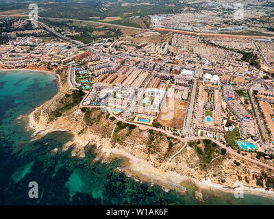 Luftaufnahmen drone Sicht der türkisfarbenen Bucht von Mittelmeer Gewässer und Küste Cabo Roig Torrevieja von oben im Sommer, Provinz Stockfoto