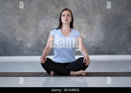 Frau Üben Yoga, Sukhasana übung, einfach Sitz dar Stockfoto