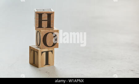 Stapel mit drei Holzwürfel - Buchstaben heiß auf Sie, Platz für mehr Text/Bilder auf der rechten Seite. Stockfoto