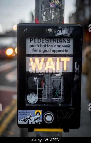 Warten, Warten an der Ampel für grünes Signal für Fußgänger, Edinburgh, Schottland, Vereinigtes Königreich Stockfoto