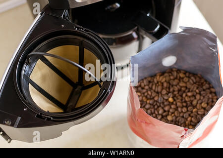 Warenkorb Kaffee Filter, Tropf-Stopp-Art Kaffeemaschine und Kaffee Bohnen auf dem Küchentisch, Ansicht von oben. Wiederverwendbare Metallgitter Kaffeefilter. Zubehör für Kaffee Stockfoto