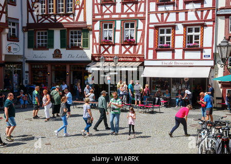 Touristen Einkaufen am Marktplatz mit Fachwerkhäusern an einem sonnigen Nachmittag. Bernkastel-Kues, Rheinland-Pfalz, Deutschland. Stockfoto