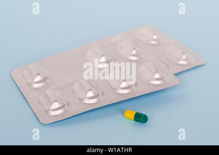 Zwei Blasen mit Pillen oder Kapseln auf blauem Hintergrund. Krank zu werden, nehmen, Pillen oder Behandlung unterzogen werden. Konzept der Health Care sowie Pharma. Stockfoto