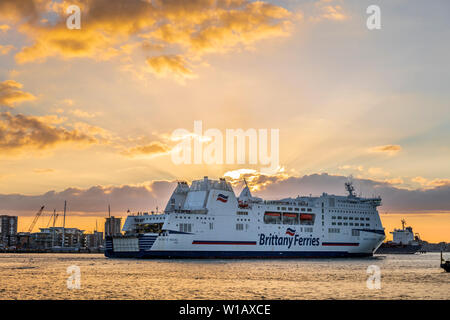 Die Menschen an Bord genießen Sie die Ansicht als "Mont St Michel', besessen und von Brittany Ferries, in Portsmouth Harbour kommt, wie die Sonne über dem Fluss setzt Stockfoto