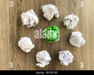 Zerknittert Papier Kugel grün unter weißen Kugeln. Stockfoto