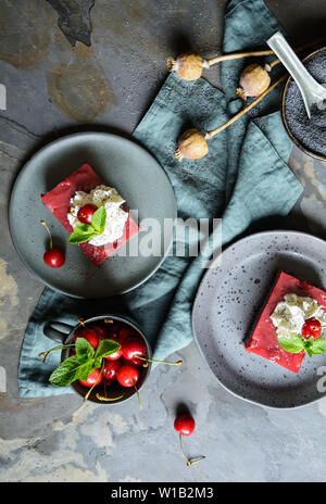 Köstliche Mohn Kuchen mit cherry Vanillepudding auf einem urigen Hintergrund Stockfoto