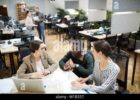 Hohe Betrachtungswinkel bei multi-ethnischen Gruppe von Menschen Lächeln beim zusammen im Büro arbeiten, kopieren Raum Stockfoto