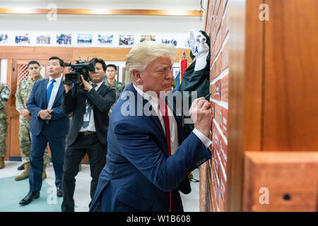 Korean Demilitarized Zone, Korea. 30th June, 2019. President Donald J. Trump signs a brick wall of celebrated visitorÕs autographs Sunday, June 30, 2019, at the Korean Demilitarized Zone. People: President Donald Trump Credit: Storms Media Group/Alamy Live News Stockfoto