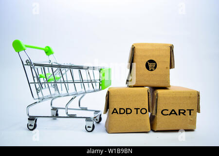 In den Warenkorb legen Text in kleine Kisten und Warenkorb hinzufügen. Konzepte über das On-line-Einkaufen. Auf weissem Hintergrund Stockfoto
