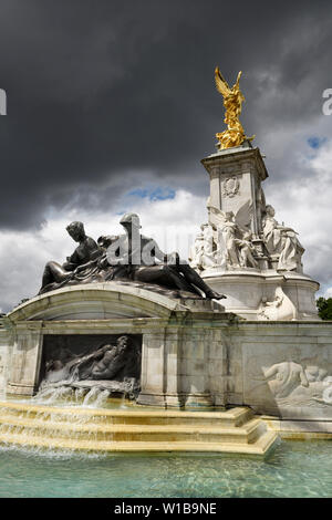 Im nautischen Stil des Victoria Memorial Denkmal für Königin Victoria und Brunnen an der Mall Buckingham Palace mit gold Winged Victory und dunkle Wolken Lon Stockfoto