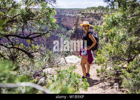 Touristische Frau mit Hände auf ihre Taille in der Nähe einer Klippe in South Rim, Grand Canyon National Park, Arizona, USA posing Stockfoto