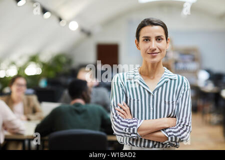 Taille bis Portrait von zuversichtlich Geschäftsfrau auf Kamera beim Posieren in Büro Stehen mit verschränkten Armen, kopieren Raum Stockfoto