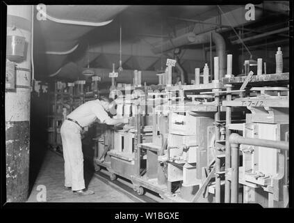 Camden, New Jersey -. RCA Victor. Kabinett Assembler-Montage Taille (vorn und an den Enden der Schaltschrank). Diese Assembler setzt auch zwei wichtige Schienen einrasten. Er ist gelernter Schreiner. Obwohl die Arbeit nicht zu Skill, nur ein Mann, der eine gründliche Kenntnis der Cabinet -, kann dieser Teil der Montage Job richtig machen müssen. Die förderanlage benötigt 20 Minuten, um eine vollständige Umdrehung zu machen. Stockfoto