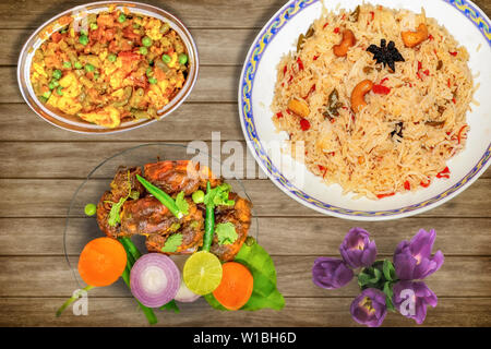 Leckeres indisches Essen Mahlzeit von gebratener Reis mit gemischtem Gemüse zusammen mit Red Hot scharf gewürzten Hummer Teller garniert mit Salat und würzig Chili Huhn Stockfoto