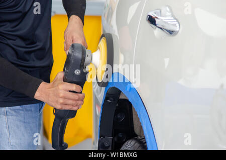 Mann bei der Arbeit Zum polieren, beschichten Autos. Stockfoto