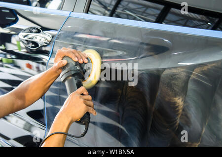 Mann bei der Arbeit Zum polieren, beschichten Autos. Stockfoto