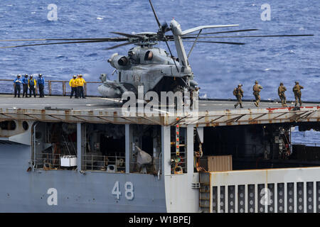 190614-N-DX 072-1048 CORAL SEA (14. Juni 2019) Marines zur 31 Marine Expeditionary Unit (MEU) Maritime Raid Kraft zugeordnet aussteigen Aussteigen aus der CH-53E Super Stallion Hubschrauber, zugeordnet zu den Marine Medium Tiltrotor Squadron (VMM) 265 (verstärkt), nach der Landung auf dem Flugdeck der Amphibischen dock Landung Schiff USS Ashland (LSD 48), da es einen Besuch, Board, Durchsuchung und Beschlagnahme (VBSS) Bohrer führt mit dem amphibious Transport dock Schiff USS Green Bay LPD (20). Green Bay, Teil der Wasp amphibischen bereit, Gruppe, mit Eingeschifft 31 MEU, im Indo-pazifischen Region zu stärken Stockfoto