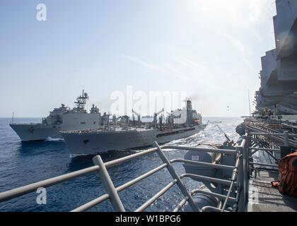 190630-N-PQ 586-1111 Golf von Aden (30.06.2019) Landung Amphibische dock Schiff USS Harpers Ferry (LSD 49), links, und Flotte Auffüllung öler ship USNS Big Horn (T-AO 198) Segeln neben Amphibisches Schiff USS Boxer (LHD4) während einer Auffüllung-auf-See. Boxer ist Teil der Boxer Amphibious Ready Gruppe und 11 Marine Expeditionary Unit und ist in die USA 5 Flotte Bereich der Maßnahmen zur Unterstützung der Marine im Einsatz für die Stabilität und Sicherheit in der Region zu gewährleisten und verbindet das Mittelmeer und den Pazifischen Raum durch den westlichen Indischen Ozean und drei strategische Cho Stockfoto