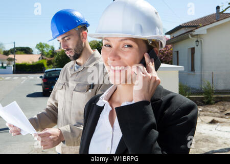 Pretty Woman Arbeiter auf dem Telefon oustide Baustelle Stockfoto