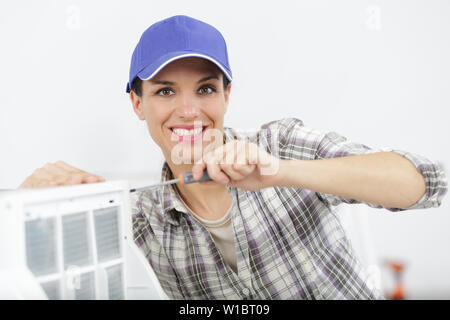 Glückliche Frau Mechaniker zur Festsetzung der Klimaanlage Stockfoto