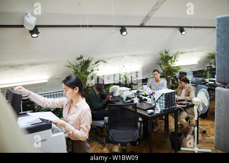 Hohen winkel Portrait von asiatischen Geschäftsfrau Dokumente scannen, während im Büro arbeiten, kopieren Raum Stockfoto