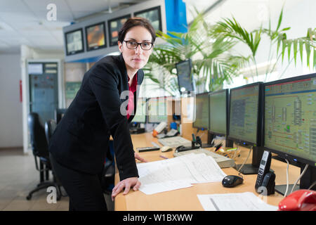 Geschäftsfrau im Büro mit TV-Bildschirmen Stockfoto