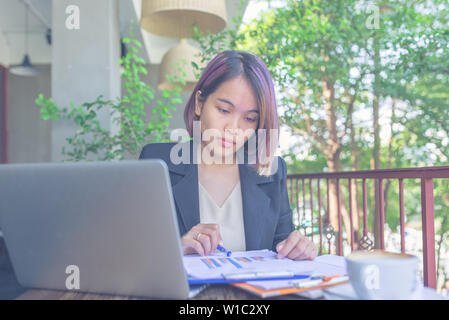 Portrait von asiatische Frau arbeiten auf Dokument und Laptop Stockfoto