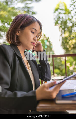 Porträt der jungen hart arbeitende Frau im schwarzen Anzug Stockfoto