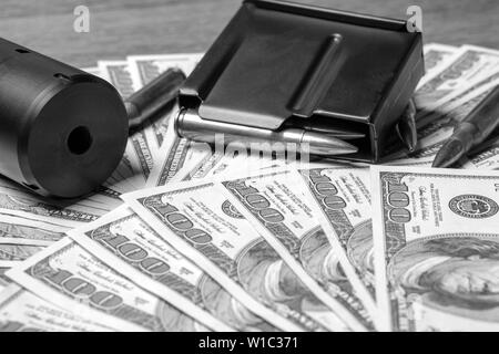Rifle barrel, Unterdrücker und Patronen auf Geld. Konzept für Kriminalität, Mord, Mörder, Terrorismus, Krieg, globalen Waffenhandel, Waffen Verkauf Stockfoto